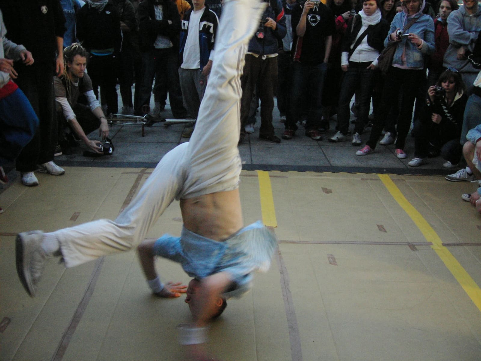 Seyirci önünde headspin yapan sokak dansçısı — çocuklar için K-Pop ve street dance rehberi